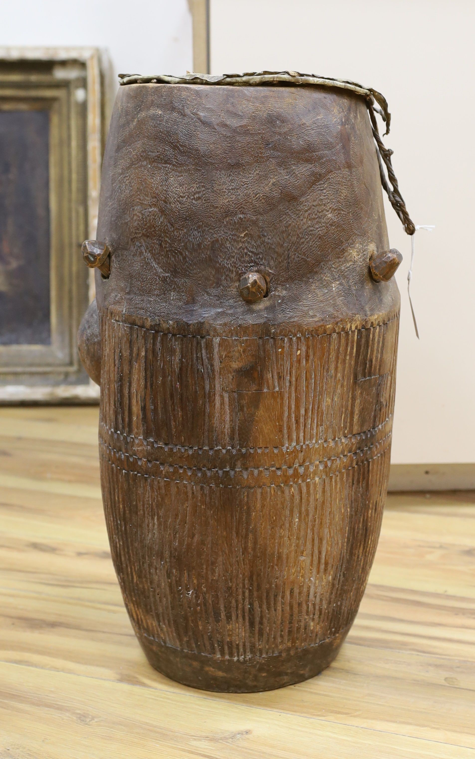 A 19th/20th century Ashanti breasted drum, 61 cms high.